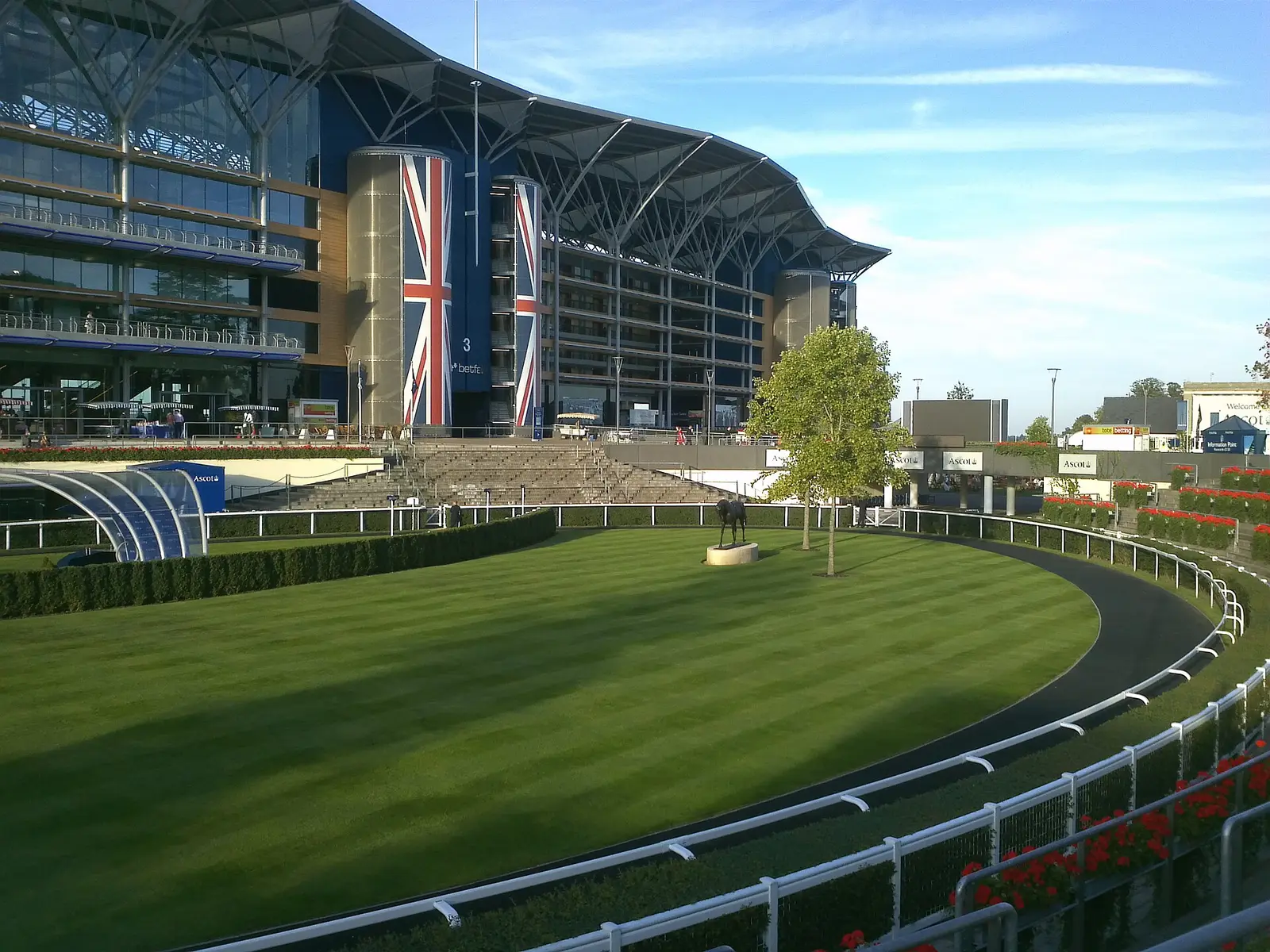 The curved grandstand and turf track at Ascot Racecourse on a sunny day