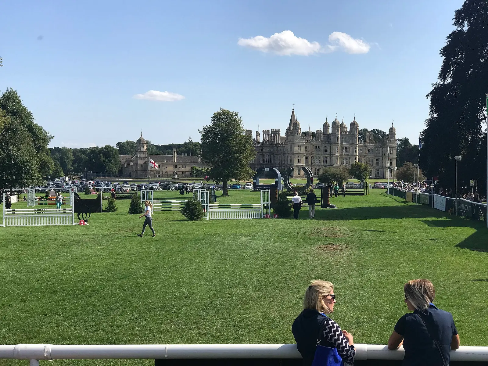 The showjumping arena at Burghley Horse Trials with Burghley House beyond the trees