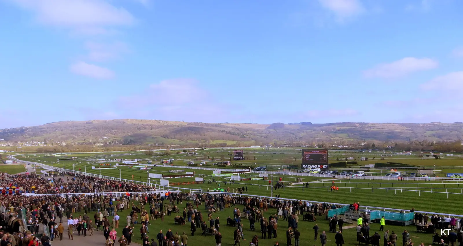 Racegoers fill the lawns and stands at Cheltenham Racecourse during the Festival with the Cotswold hills behind