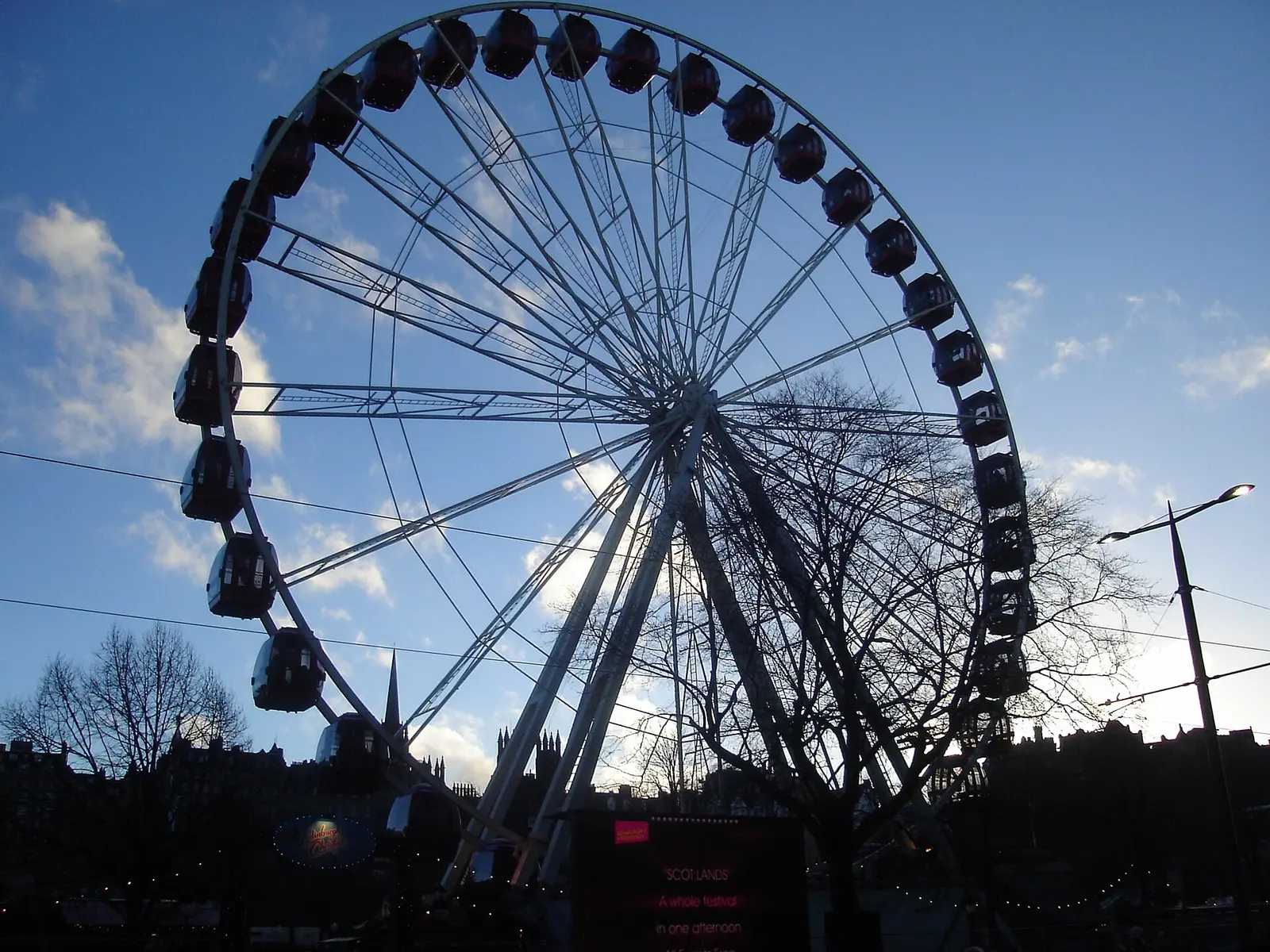 The big wheel stands against a blue sky above Edinburgh rooftops during Hogmanay 2013 to 2014