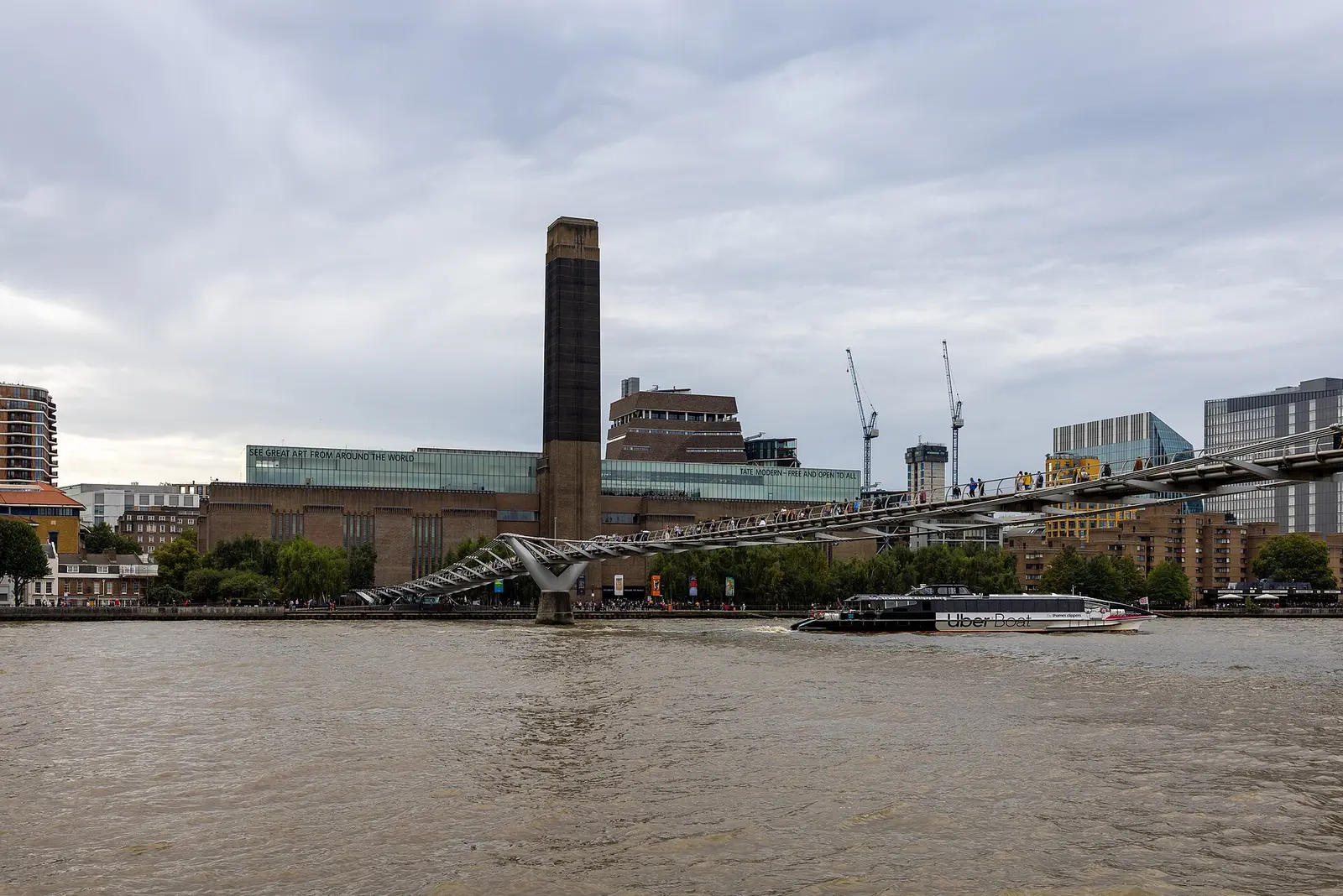 Tate Modern and its chimney beside the Millennium Bridge across the Thames