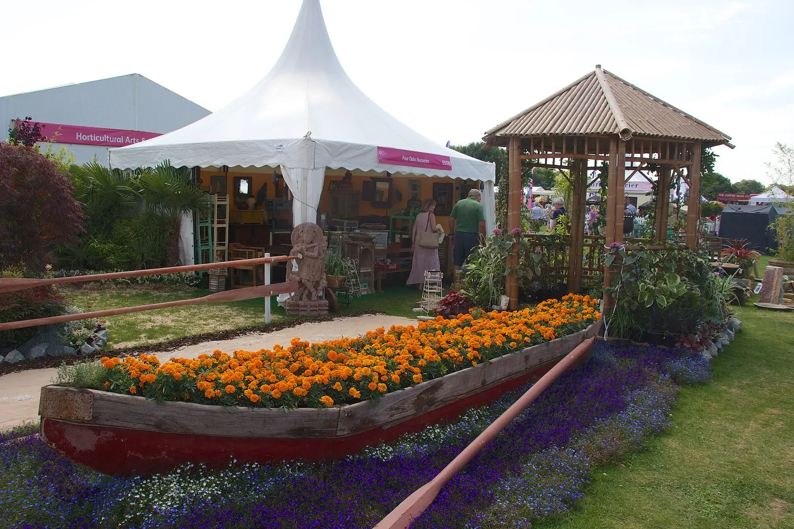 A show garden with a boat-shaped flower bed and a white marquee at the Tatton Park Flower Show in 2014